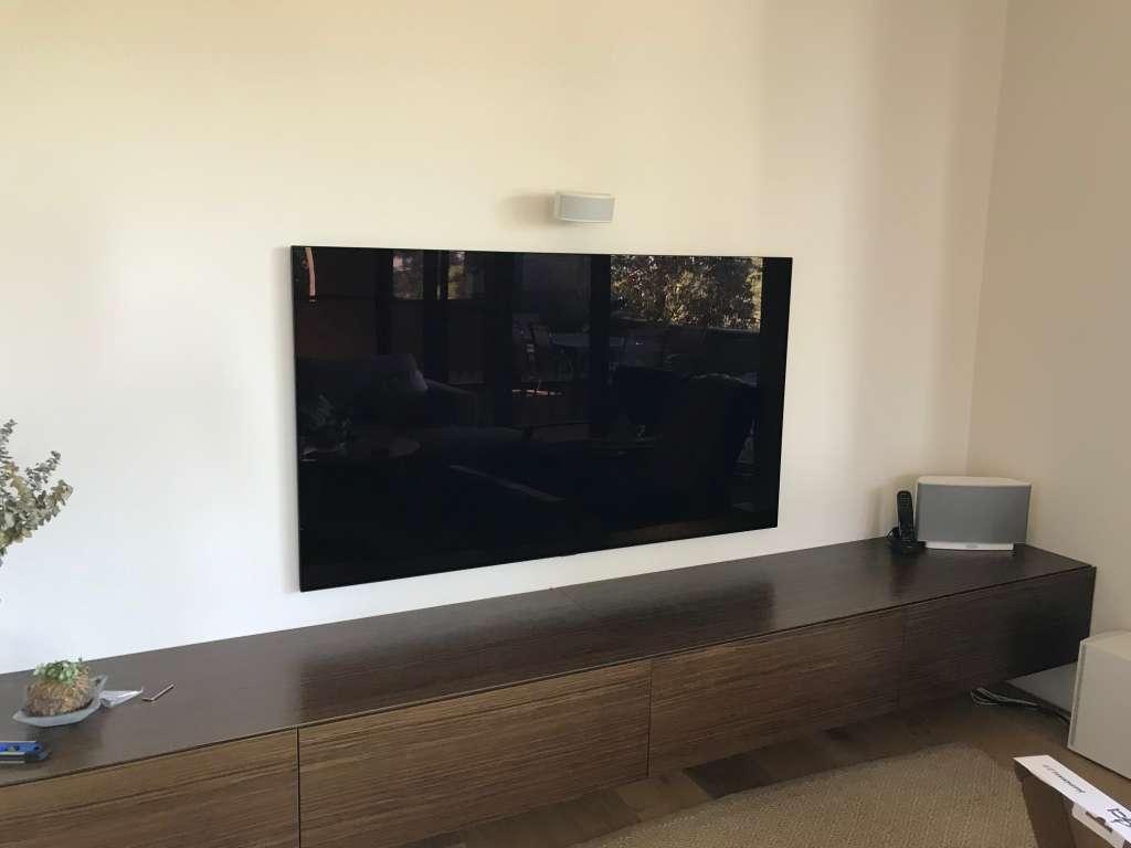 TV wall mounted with a floating cabinet below